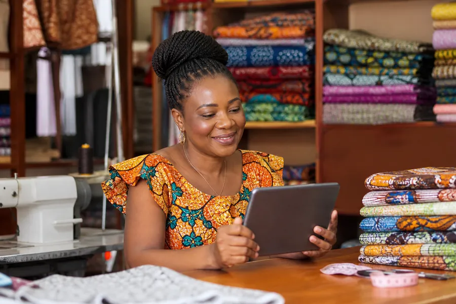 Commerçante consultant un tableau de gestion sur une tablette dans son atelier